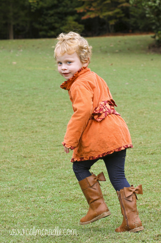 Portraits: Toddler with orange coat and curls running around the Sarah P. Duke Gardens. Durham, NC. By Calm Cradle Photo & Design