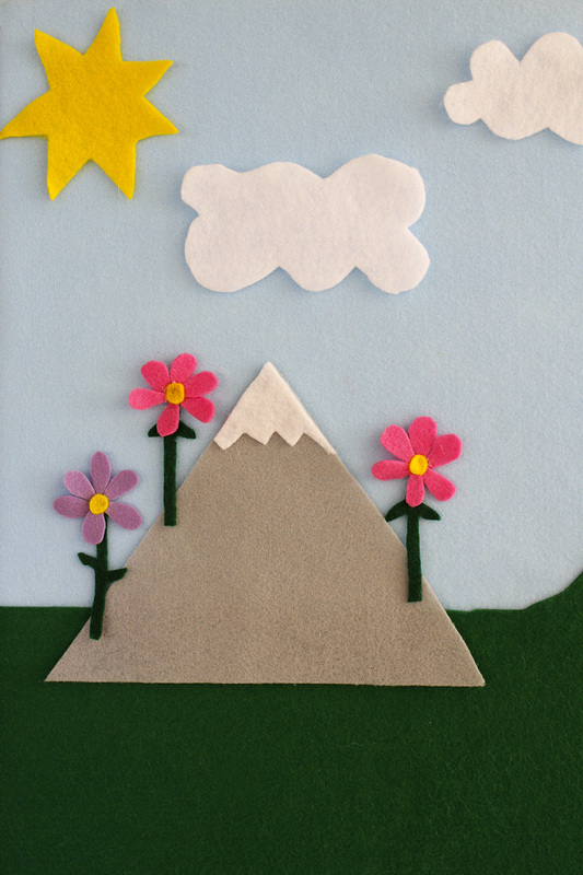 Felt board with mountain, flowers, clouds and sun. By Calm Cradle Photo & Design