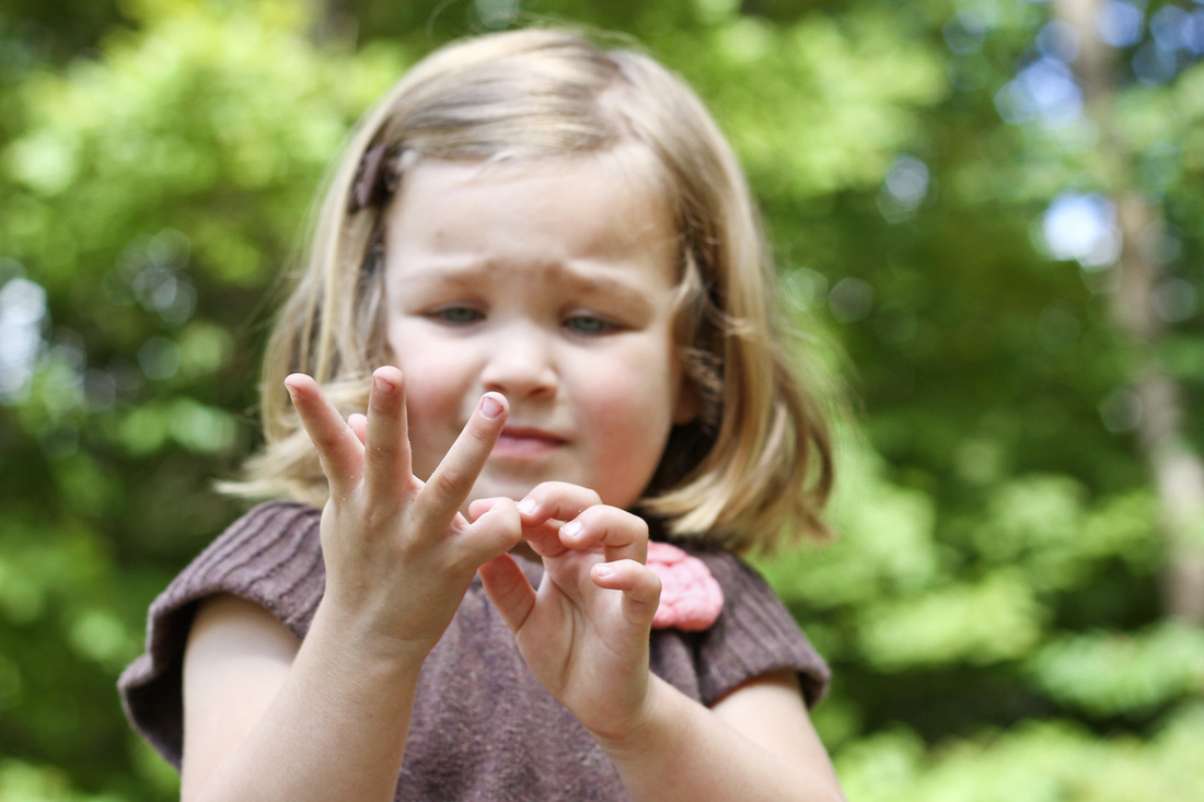 Portrait of 3-year-old trying to hold up 3 fingers. By Calm Cradle Photo & Design