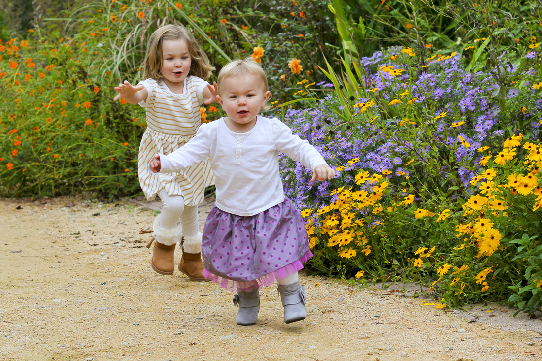 A game of sister chase in the garden. By Calm Cradle Photo & Design