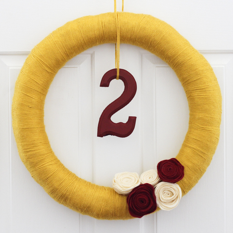 Fall DIY: Yarn wreath with felt flowers in yellow, red and white. Hang a number or letter for a birthday celebration. By Calm Cradle Photo & Design