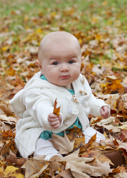 Six-month portraits: Baby in turquoise sitting in orange leaves. Calm Cradle Photo & Design